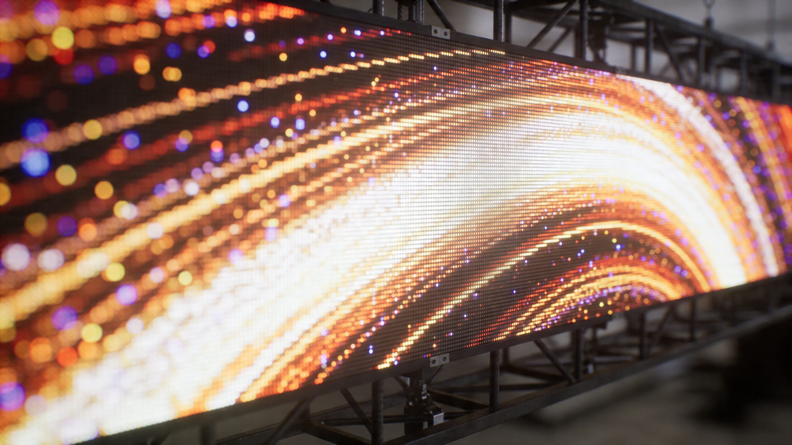 A close-up view of a large digital LED screen displaying abstract flowing orange and white light patterns.